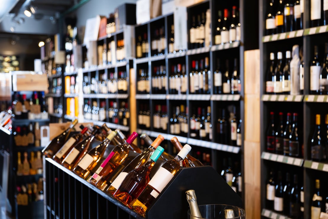 Rack with various wine bottles in modern wine store waiting for customers